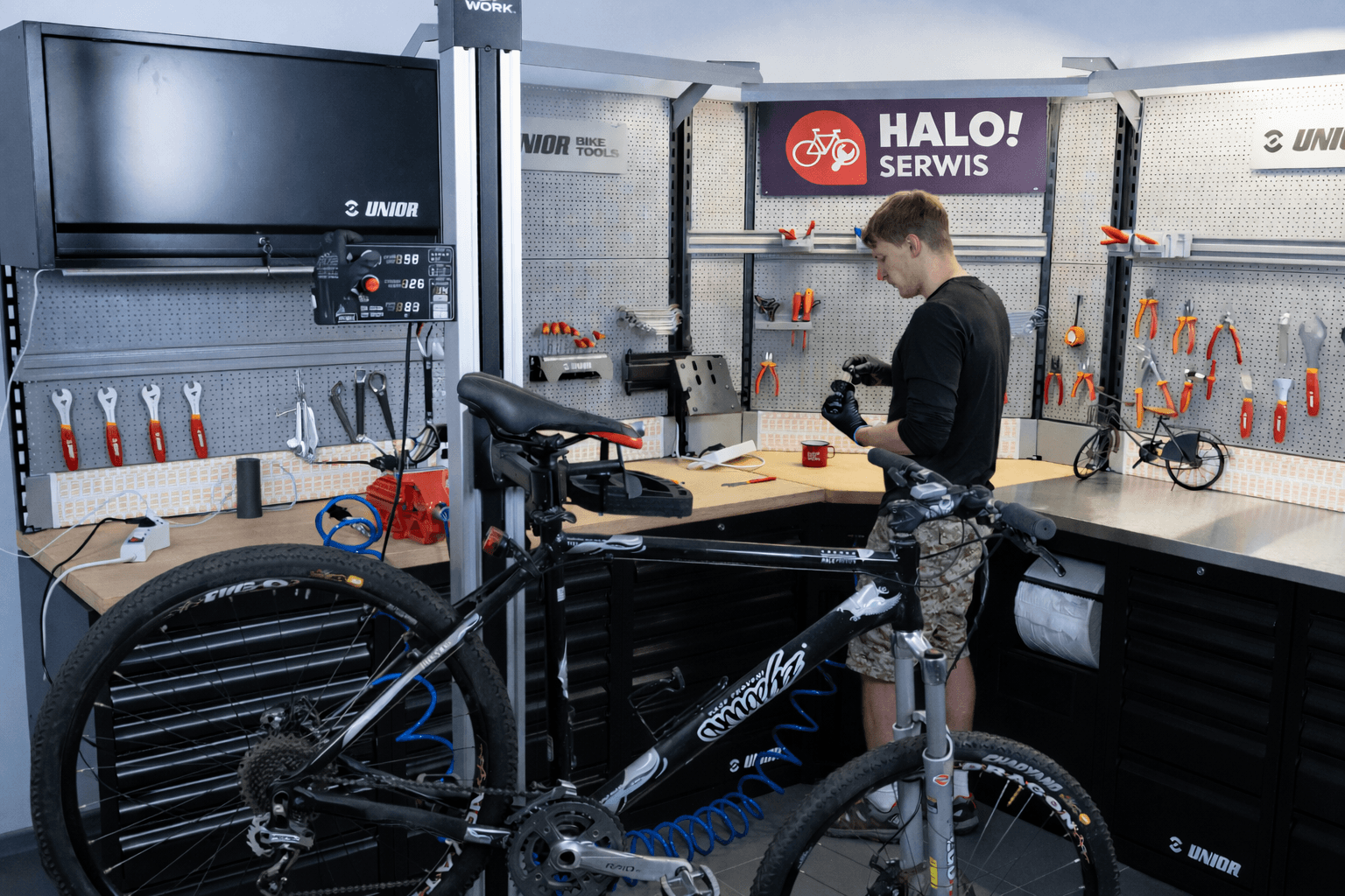Mechanik naprawiający rower na stanowisku serwisowym HALO! Serwis